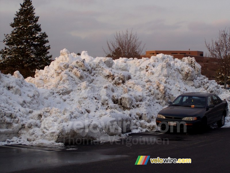 Sneeuwbergje op de parkeerplaats voor het winkelcentrum