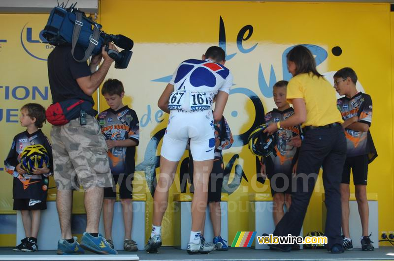 Matthieu Ladagnous (Française des Jeux) reikt helmen uit aan 9 jonge renners
