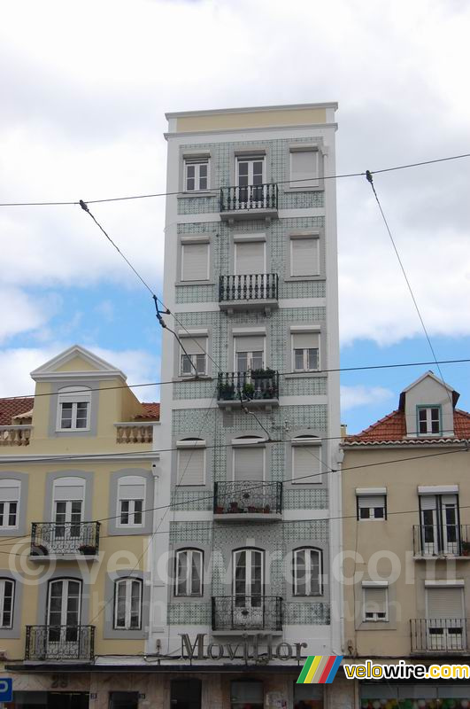Een hoog huis met blauw/groene mozaïeken tegeltjes