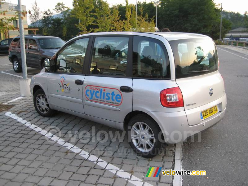 De auto van de Fédération Française de Cyclisme / het magazine La France Cycliste bij de supermarkt